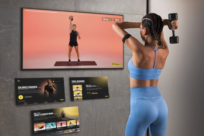 Woman working out with Technogym app on Samsung tv