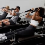 Peloton köper Pilates-startup – kan vara på väg in i reformer-Pilates Grupp av människor tränar pilates på reformer-maskiner