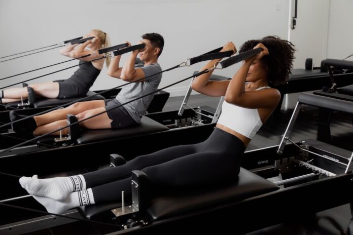 pilates-reformer Grupp av människor tränar pilates på reformer-maskiner