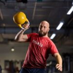 Friskis&Svettis Malmö söker Träningschef Man i Friskiströja styrketränar med kettlebell