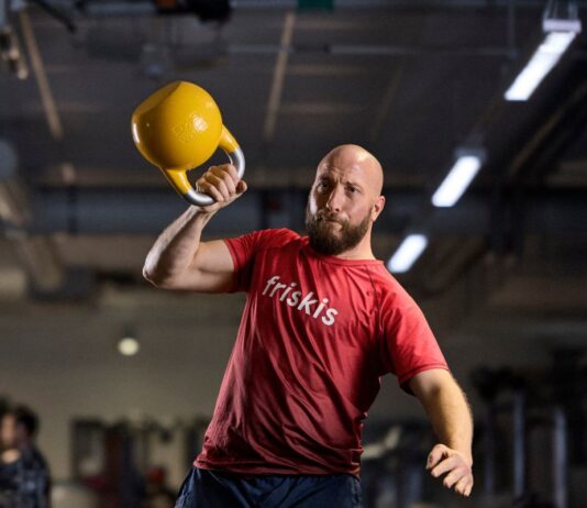 Friskis&Svettis Malmö söker Träningschef Man i Friskiströja styrketränar med kettlebell