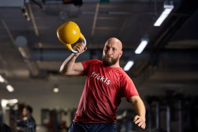 Friskis_gym_träning Man i Friskiströja styrketränar med kettlebell