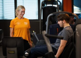 Medley satsar på onboarding – vill höja träningsfrekvensen och förbättra folkhälsan Kvinnlig personlig tränare på Medley instruerar man som styrketränar i maskin